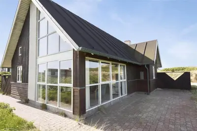 a house with a black roof and large windows at BL1357-Blokhus-Ved-Stranden-2 in Blokhus