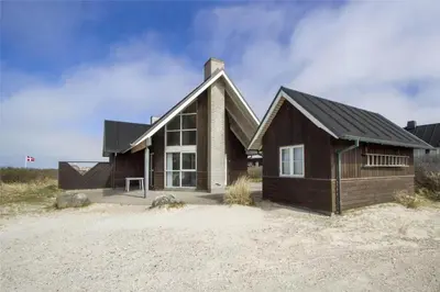 a wooden house with a gambrel roof at BL1357-Blokhus-Ved-Stranden-2 in Blokhus