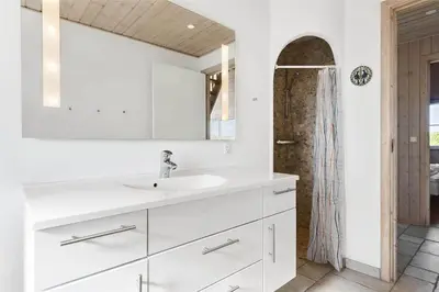a white bathroom with a sink and a shower at BL1357-Blokhus-Ved-Stranden-2 in Blokhus