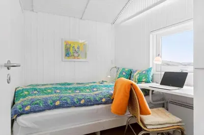 a bedroom with a bed and a desk with a laptop at BL832-Saltum-Kohlsvej-8 in Saltum