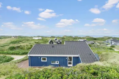 a blue house with a solar roof on the beach at BL832-Saltum-Kohlsvej-8 in Saltum