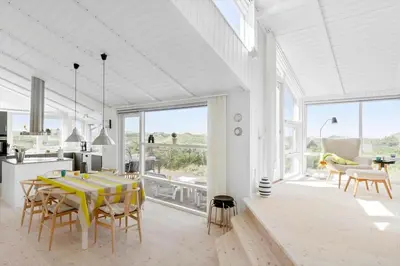 a white kitchen and dining room with a table and chairs at BL832-Saltum-Kohlsvej-8 in Saltum