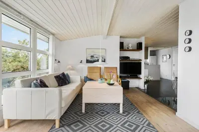 a living room with a white couch and a table at BL374-Blokhus-Vagerfedet-10 in Blokhus