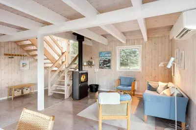 a living room with a blue couch and a staircase at BL1362-Saltum-Kronhjortvej-19 in Saltum