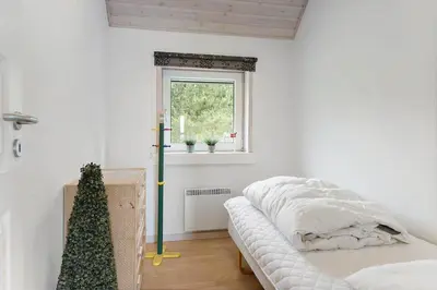 a white room with a bed and a christmas tree at BL381-Blokhus-Maxvej-4 in Blokhus
