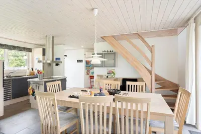 a kitchen and dining room with a table and chairs at BL381-Blokhus-Maxvej-4 in Blokhus