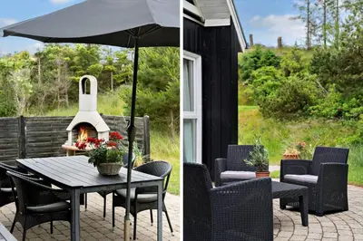 a patio with a table and an umbrella at BL381-Blokhus-Maxvej-4 in Blokhus