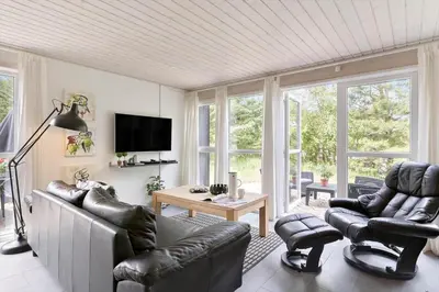 a living room with leather chairs and a television at BL381-Blokhus-Maxvej-4 in Blokhus