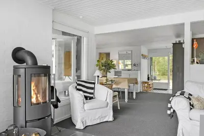 a living room with a fireplace in the middle of a room at BL1467-Saltum-Solmarken-4 in Saltum