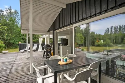 a patio with a table and chairs on a deck at BL1467-Saltum-Solmarken-4 in Saltum