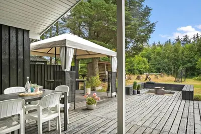 a patio with a table and an umbrella at BL1467-Saltum-Solmarken-4 in Saltum