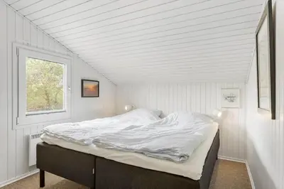 a bed in a white room with a window at BL1418-Blokhus-Malinsvej-14 in Blokhus