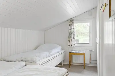 a white room with two beds and a window at BL1418-Blokhus-Malinsvej-14 in Blokhus