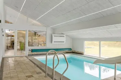 a swimming pool in a room with a large window at BL1418-Blokhus-Malinsvej-14 in Blokhus