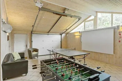 a room with a ping pong table and a screen at BL1418-Blokhus-Malinsvej-14 in Blokhus