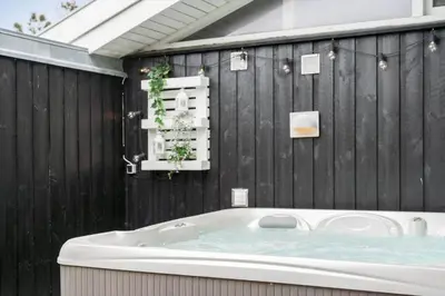 a bath tub in a bathroom with a wooden wall at BL1418-Blokhus-Malinsvej-14 in Blokhus
