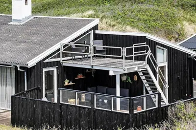 a black house with stairs on the side of it at BL1746-Saltum-Kalundborgvej-23 in Saltum
