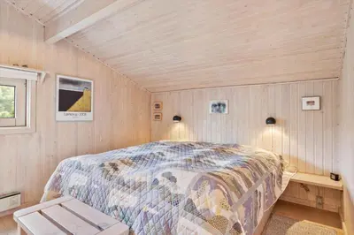a bedroom with a bed in a room with wooden walls at BL1263-Saltum-Ornebjergvej-25 in Saltum