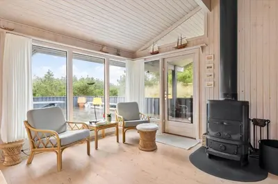a living room with two chairs and a wood stove at BL1263-Saltum-Ornebjergvej-25 in Saltum