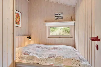 a small bedroom with a bed and a window at BL1263-Saltum-Ornebjergvej-25 in Saltum