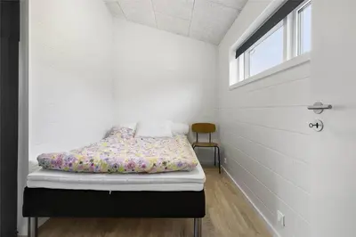 a bed in a room with a window at BL1442-Blokhus-Bag-Hojen-43 in Blokhus