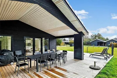 a patio with a table and chairs on a deck at BL1442-Blokhus-Bag-Hojen-43 in Blokhus