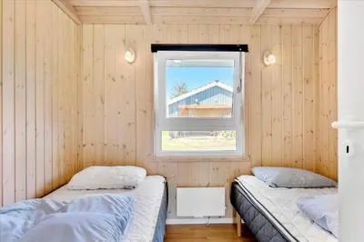 two beds in a room with a window at BL1751-Blokhus-Wolundsvej-4-A in Blokhus
