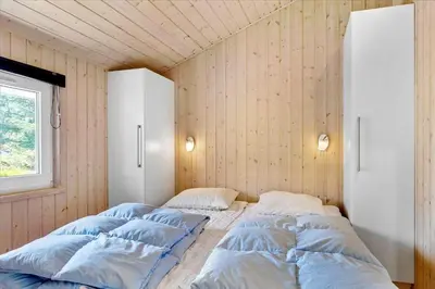 two beds in a room with wooden walls at BL1751-Blokhus-Wolundsvej-4-A in Blokhus