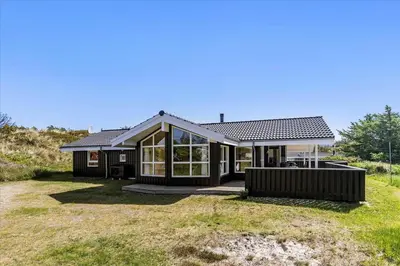 a home with a black house with a large yard at BL1751-Blokhus-Wolundsvej-4-A in Blokhus