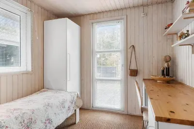 a bedroom with a bed and a white refrigerator at BL1213-Pandrup-Rodhusparken-14 in Pandrup
