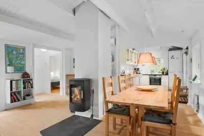 a kitchen and dining room with a table and a fireplace at BL554-Blokhus-Kragebak-2 in Blokhus