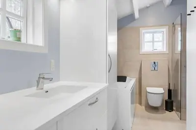 a white bathroom with a sink and a toilet at BL554-Blokhus-Kragebak-2 in Blokhus