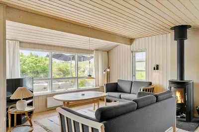 a living room with a couch and a fireplace at BL220-Blokhus-Bakkevaenget-9 in Blokhus