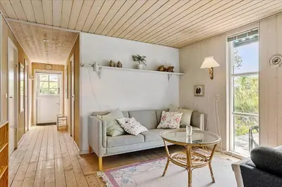 a living room with a couch and a glass table at BL220-Blokhus-Bakkevaenget-9 in Blokhus