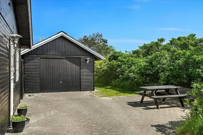 a wooden garage with a picnic table and a bench at BL220-Blokhus-Bakkevaenget-9 in Blokhus
