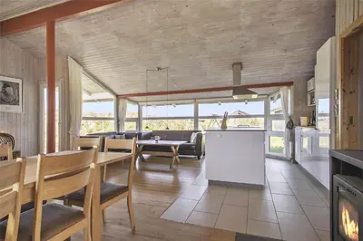 a kitchen and living room with a table and chairs at BL758-Pandrup-Hunetorp-Klitvej-237 in Pandrup