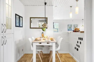 a white dining room with a white table and chairs at BL1206-Blokhus-Blaabaervej-6 in Blokhus