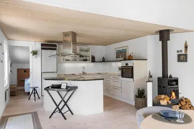 a kitchen with white cabinets and a table in it at BL1371-Blokhus-Sletten-10-A in Blokhus