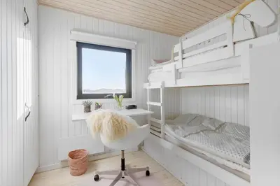 a small bedroom with a bunk bed and a chair at BL1529-Pandrup-Ferborgvej-58 in Pandrup