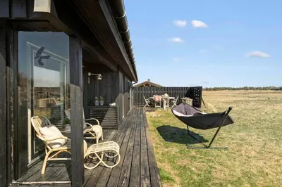 a porch of a house with chairs and a grill at BL1529-Pandrup-Ferborgvej-58 in Pandrup