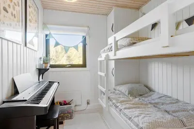a small bedroom with a piano and a bed at BL1529-Pandrup-Ferborgvej-58 in Pandrup