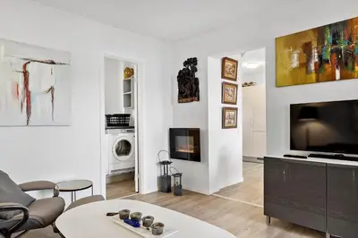 a living room with a couch and a tv at BL1260-Blokhus-Strandvejen-14-Lejl-9 in Blokhus
