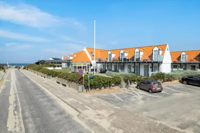 a parking lot in front of a large building at BL1260-Blokhus-Strandvejen-14-Lejl-9 in Blokhus