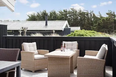 a patio with wicker chairs and a table on a deck at BL687-Saltum-Porsevej-16 in Saltum