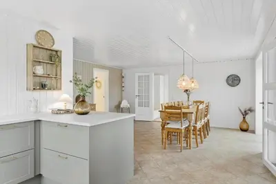 a kitchen and dining room with a table and chairs at BL1246-Blokhus-Vigen-6 in Blokhus