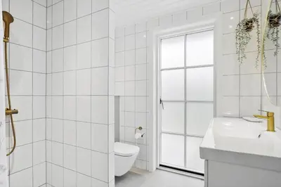 a white bathroom with a toilet and a sink at BL1246-Blokhus-Vigen-6 in Blokhus