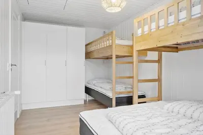 a bedroom with two bunk beds and a bed at BL1246-Blokhus-Vigen-6 in Blokhus