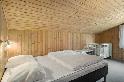 a bedroom with a large bed in a wooden wall at BL1781-Saltum-Ornebjergvej-26 in Saltum