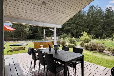a wooden deck with a table and chairs on it at BL1781-Saltum-Ornebjergvej-26 in Saltum