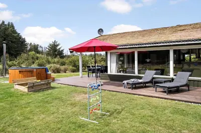 a backyard with a swing set and an umbrella at BL1781-Saltum-Ornebjergvej-26 in Saltum